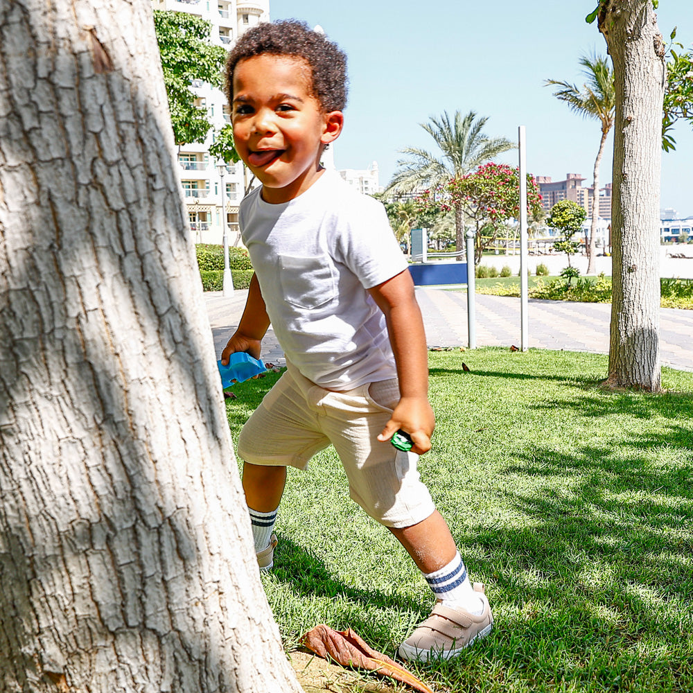boy wearing cream colour shorts made from organic cotton by Hiccups & Buttercups