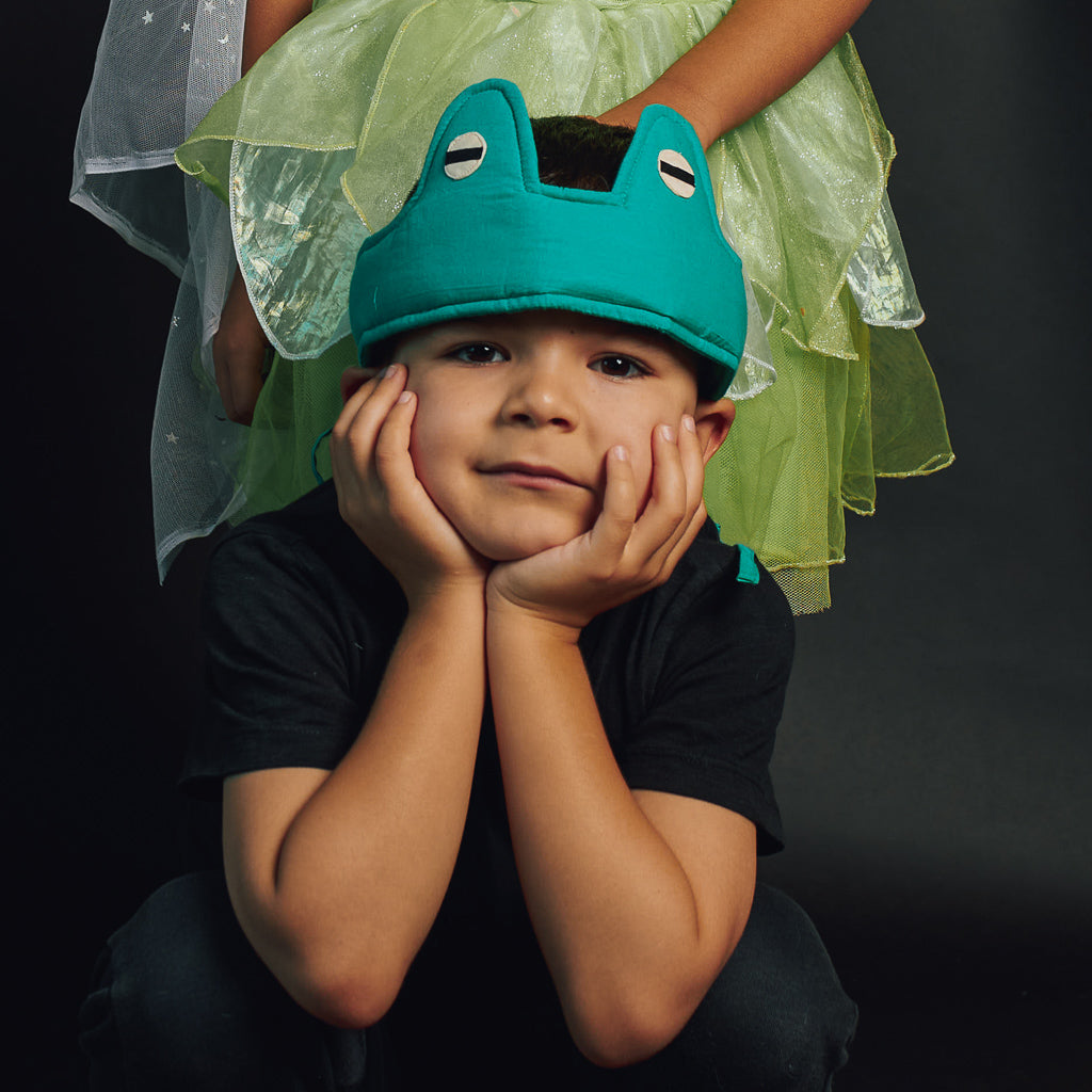 A boy with his hands on his face wearing dress up Frog Eyes from Hiccups & Buttercups