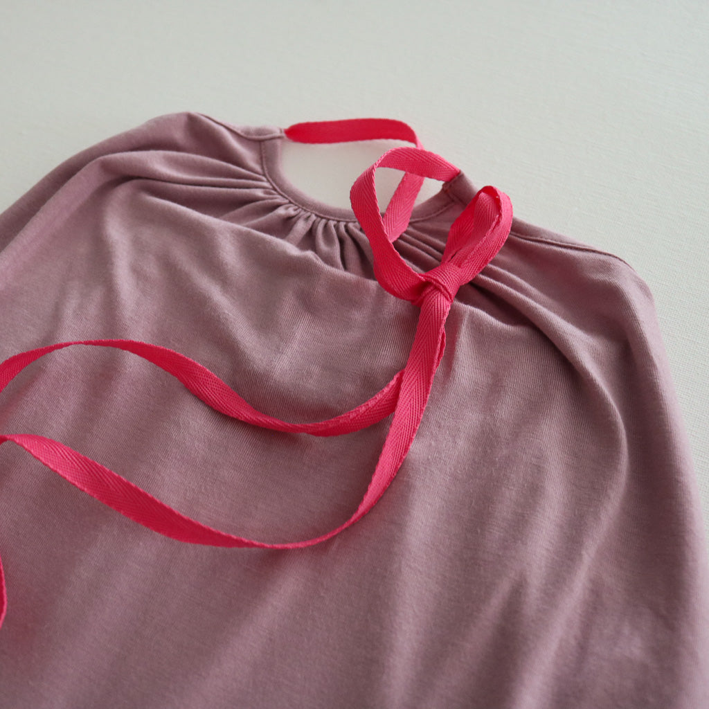 A pastel pink Halter Neck romper by Hiccups & Buttercups