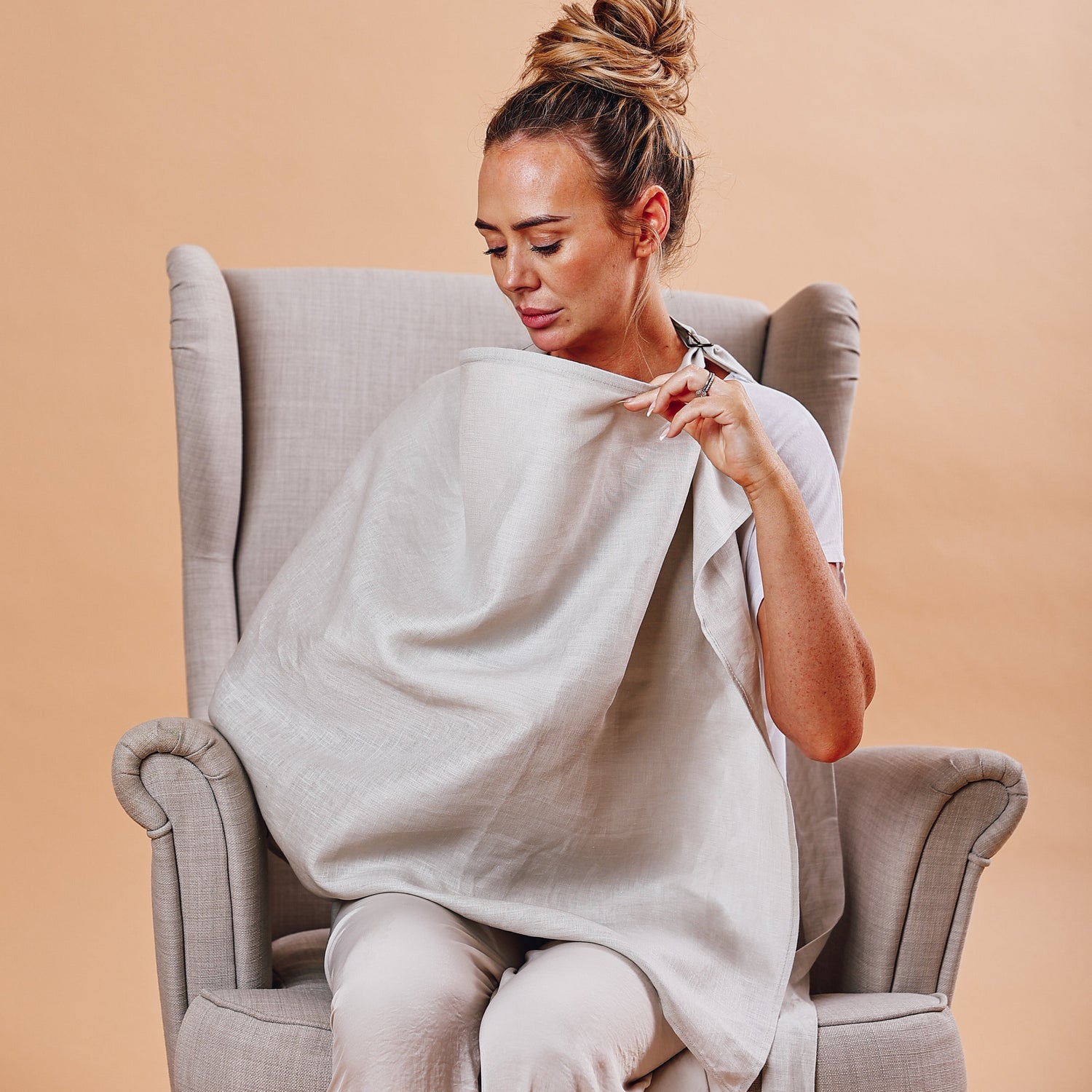 A mother nursing her baby using a Hiccups and Buttercups nursing cover