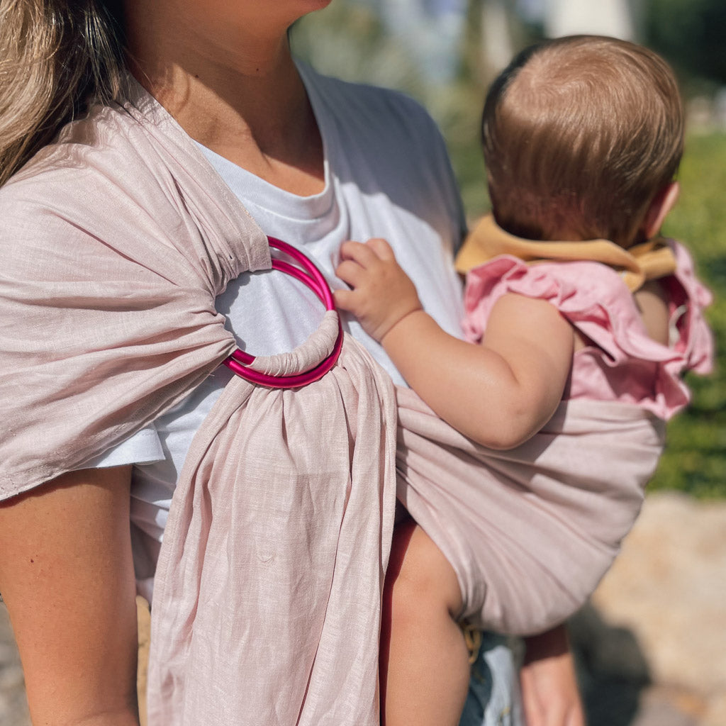 A mother wearing a Hiccups & Buttercups baby sling with her baby