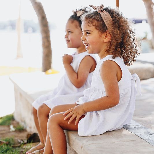 two girls wearing a white organic cotton Summer Dress from Hiccups & Buttercups