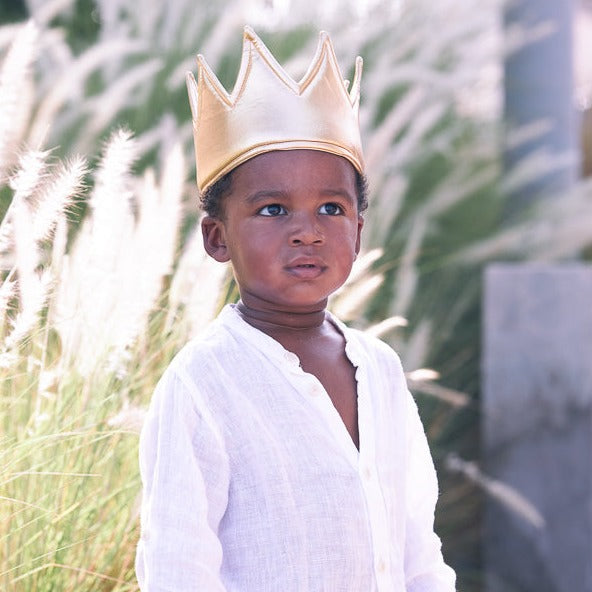 A boy wearing a gold dress up crown by Hiccups & Buttercups