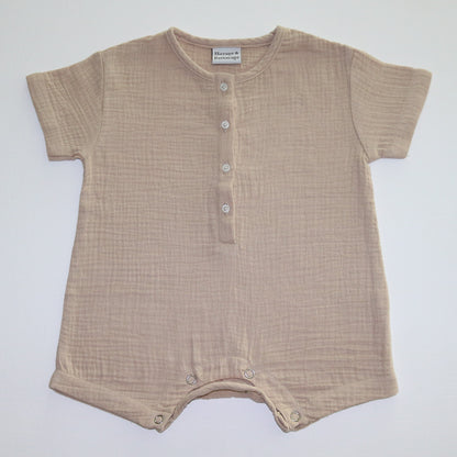 A beige short-sleeve cotton baby romper by Hiccups & Buttercups