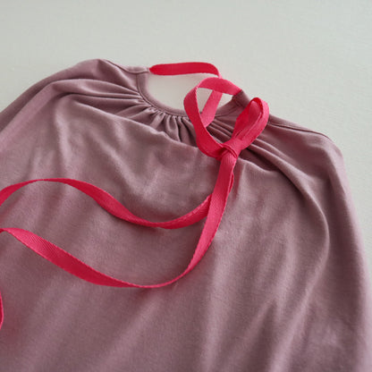 A pastel pink Halter Neck romper by Hiccups & Buttercups
