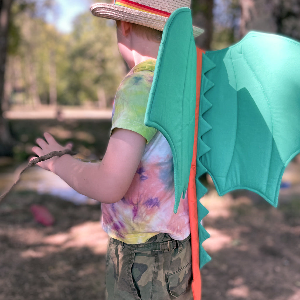 a boy playing in the woods wearing a Dragon Wing from Hiccups & Buttercups